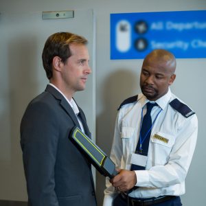 airport-security-officer-using-hand-held-metal-detector-check-commuter-scaled-e1722781082493.jpg